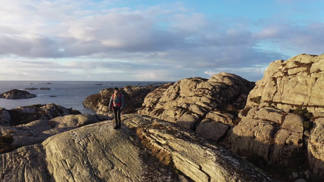 一名女性户外探险的无人机镜头:在挪威徒步旅行，在峡湾边的山上视频下载