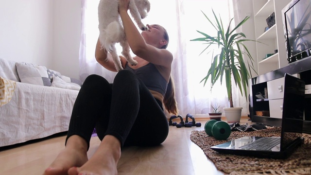 一个女人和她可爱的狗在家里锻炼视频下载