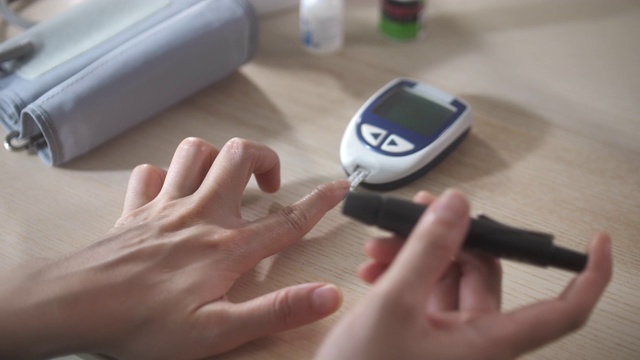 一名妇女通过血糖检测检查血糖水平视频素材
