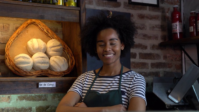 黑人快活的年轻女子在面包店对着镜头微笑视频下载