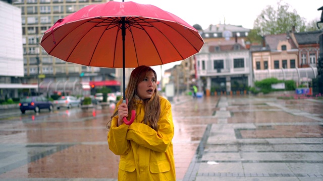 女人在雨天和寒冷的日子里在城市里。视频下载