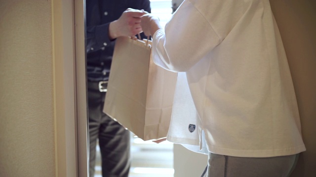 一个日本妇女在前门收到一个纸袋视频下载