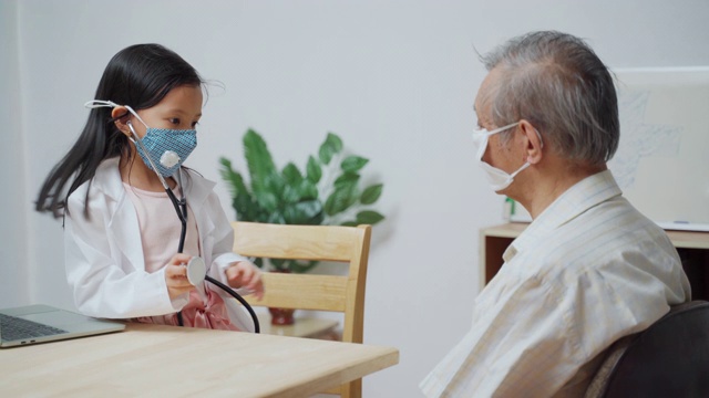 泰国可爱的女孩玩是医生检查一个老男人病人使用听诊器在家视频下载