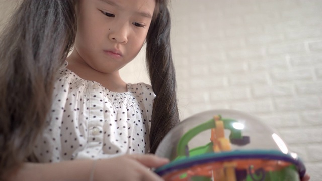 可爱的小女孩在家里的卧室里玩正在发展的玩具视频素材