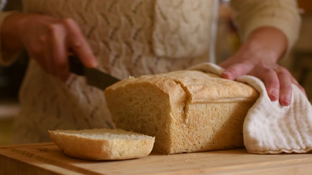 一个女人切新鲜面包的视频。视频下载
