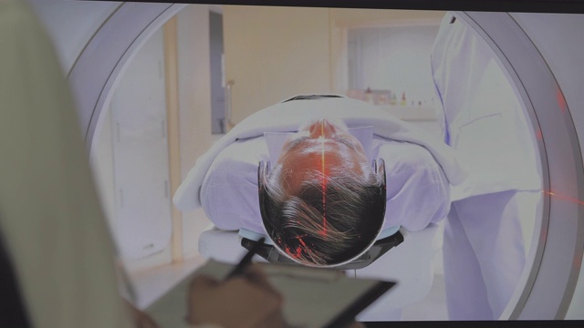 亚洲女医生与卫生保健工作人员观察在扫描室在一个新的现代治疗医院由资深男性患者扫描MRI, CT扫描仪程序。磁共振检查。视频下载