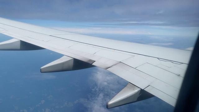 在一个阳光明媚的日子，从一个商业航空公司的飞机飞过云层和降落的机翼上的观点视频素材