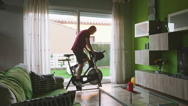 男人在家锻炼自行车视频素材