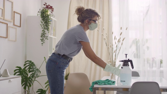 在客厅清洁时使用消毒喷雾的妇女视频素材