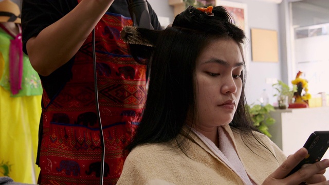 亚洲美女她使用美发沙龙的洗头和吹头发服务。视频素材