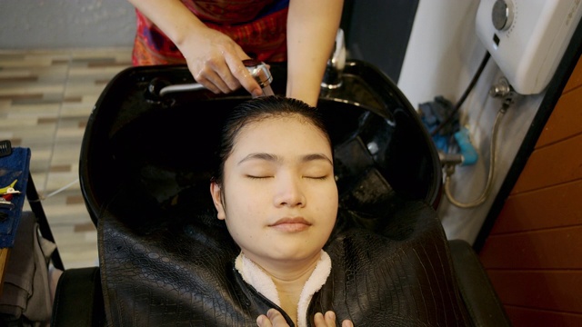 美丽的女人她使用美发沙龙的洗头服务。视频素材