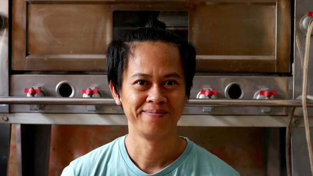 一个亚洲人在烤炉前微笑。视频下载