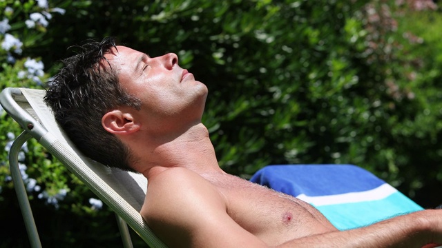 英俊的年轻人在外面晒太阳。享受假期的人，休息一下。吸收维生素D视频下载
