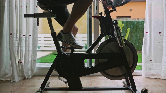 把男人在家骑健身自行车锻炼的视频搬出来视频素材