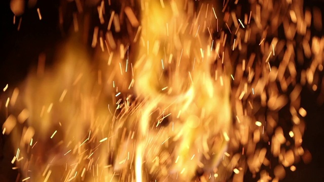 壁炉的微距火焰和火花燃烧在慢动作。篝火火花飞视频素材