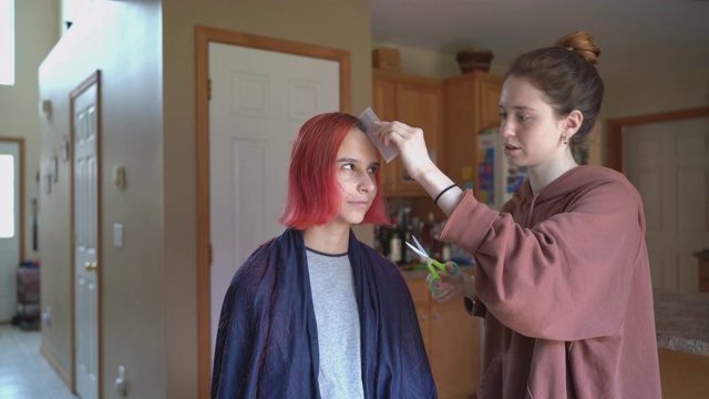 姐姐在家给妹妹剪头发，两人一起玩。视频素材