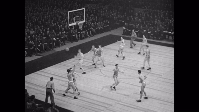 高角度观看篮球运动员在体育场上打篮球的观众视频下载