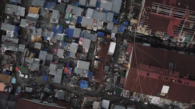 上升旋转鸟瞰空中飞行烧毁的房子显示棚户区，Tondo，马尼拉，菲律宾Tags:烧毁，火灾，邻居，混乱，第三世界，生活，混乱，烟雾缭绕的山，社区，棚屋，拥挤，小房子，u视频下载