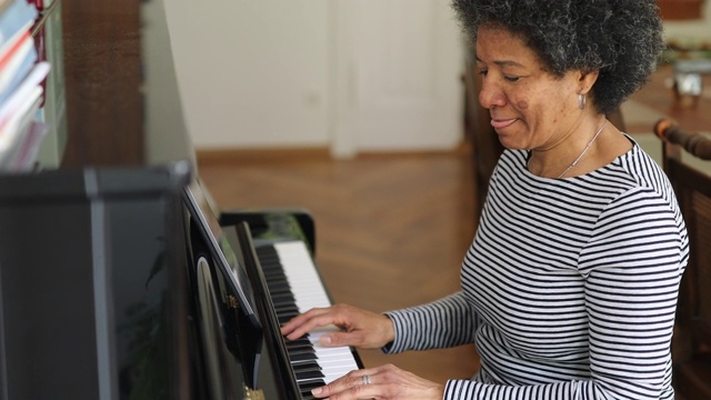 2019冠状病毒病大流行期间，妇女在家学习弹钢琴视频下载