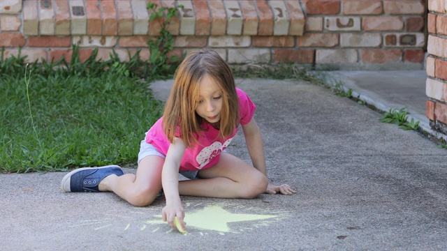 年轻女孩在车道上画粉笔视频素材