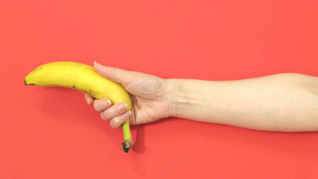 女人拿着香蕉一样的枪指着红色视频素材