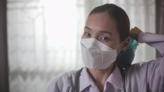 自信的亚洲女医生在实验室摘除她的外科口罩和眼镜视频素材