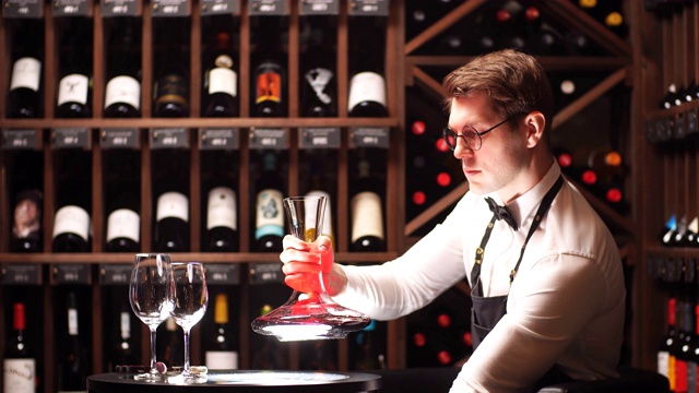 品酒师或咀嚼者将红酒倒入杯中，使其色泽完美视频下载