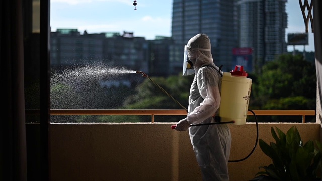 一名穿着防护服的男子向房屋喷洒杀虫剂并为房屋害虫防治病毒进行消毒视频下载