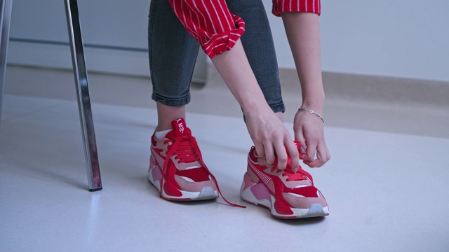 女人试图把鞋带系在运动鞋上。视频下载