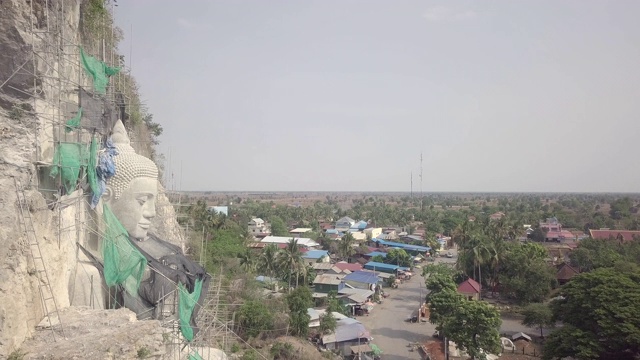 无人机拍摄的佛像与竹脚手架的建设。村庄为背景视频素材