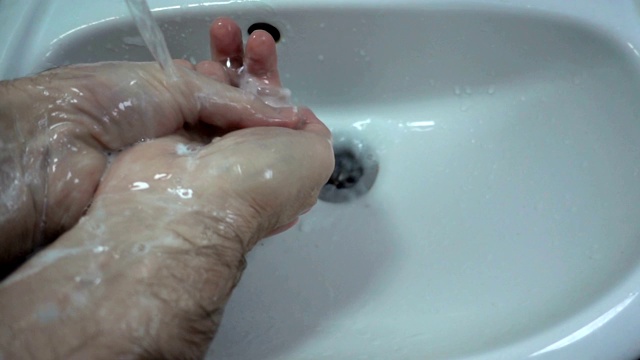 慢镜头用肥皂在水槽里洗手。视频素材