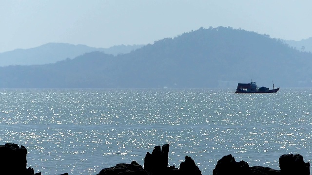 从岩石滩上看到的小船。视频下载
