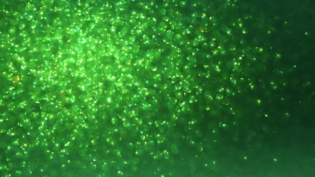 绿色闪光背景与闪闪发光的纹理。绿色闪烁的光。视频素材