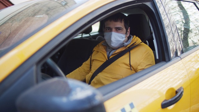 戴着防护面具和橡胶手套开出租车的男人视频下载