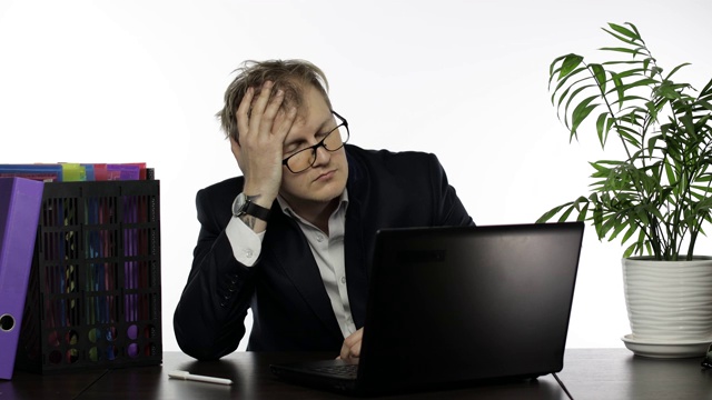 疲惫不堪，衣衫不整的商人在办公室书桌上用笔记本电脑努力工作视频素材