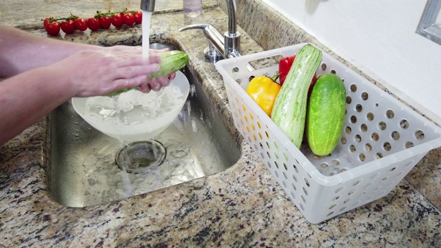 特写的手，洗蔬菜(西葫芦)在家庭厨房水槽视频下载