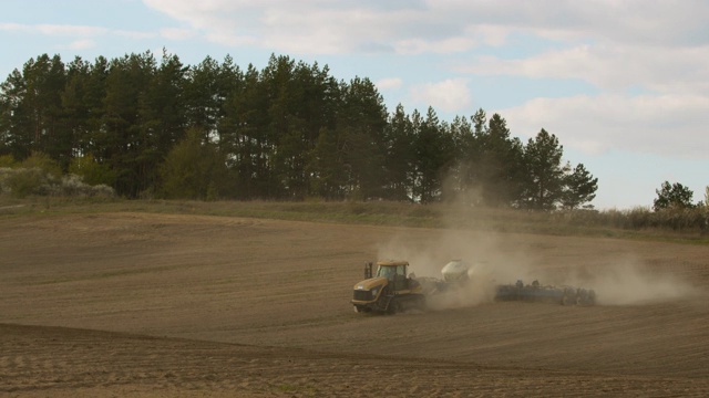 无人驾驶飞机射击。一台拖拉机正在耕地。准备播种。4 k视频素材