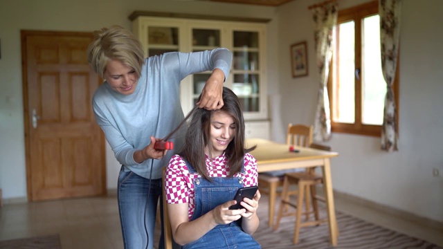 母亲把女儿的头发拉直视频素材