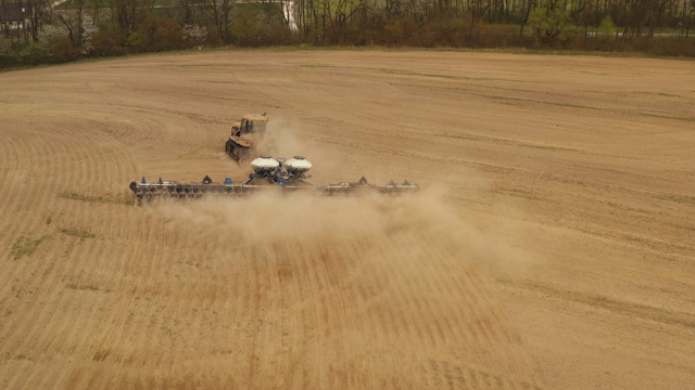 用无人机射击。一台拖拉机正在耕地。4 k视频素材