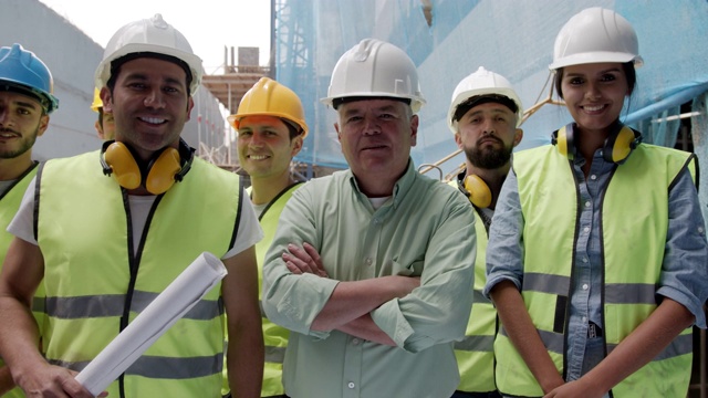 一群兴高采烈的承包商在建筑工地面对镜头微笑视频素材