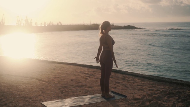 清晨阳光下做瑜伽的女人的剪影视频素材