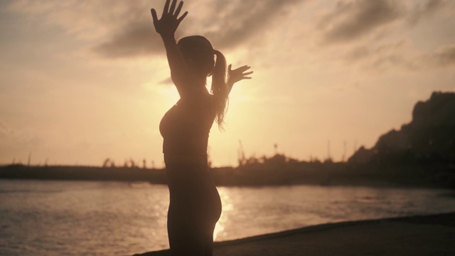 清晨阳光下做瑜伽的女人的剪影视频素材
