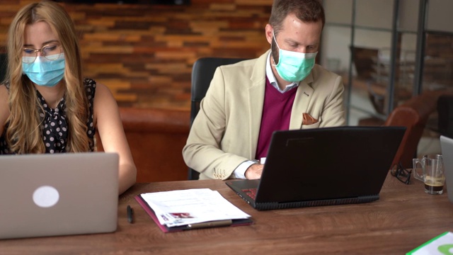 2019冠状病毒病大流行期间在办公室戴口罩的商务人士视频下载