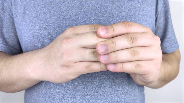 手指关节疼痛。一个男人搓着他的手指，手指又痛又扯。关节关节炎及其治疗。视频素材