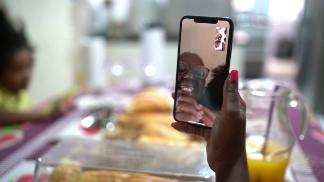 女人在家里吃早餐时用手机视频聊天视频素材