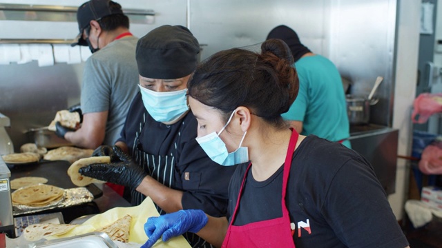 在Covid-19封锁期间，厨师在工作时戴着口罩和手套烹饪墨西哥菜视频下载