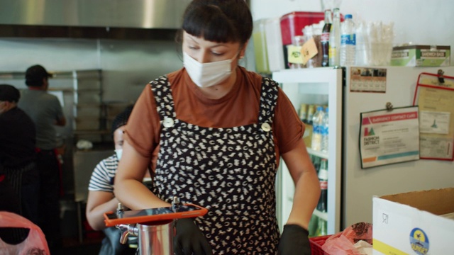 新冠肺炎封锁期间，忙碌的餐厅员工戴着口罩和手套工作视频素材