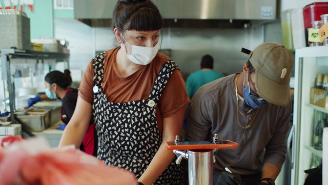 2019冠状病毒肺炎封锁期间，蒙面餐厅工作人员通过电话点菜和在厨房工作视频素材
