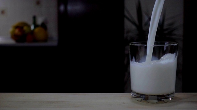 一股牛奶流以慢动作倒进玻璃杯视频素材