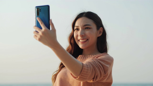 亚洲美女在海上使用智能手机。微笑着用手机的女人。生活方式，科技和旅游概念。视频素材